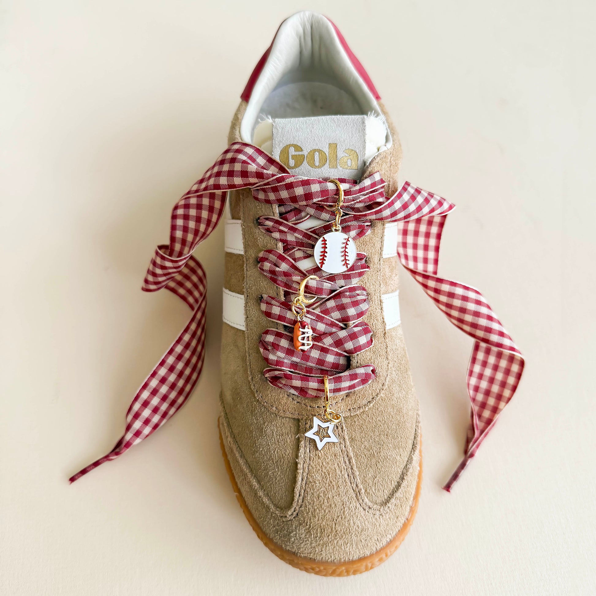 Beige sneaker with red gingham laces and baseball-themed shoe charms