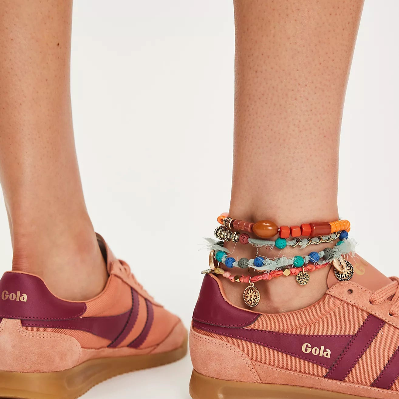 Pair of pink and purple sneakers with 'Gola' branding on a white background