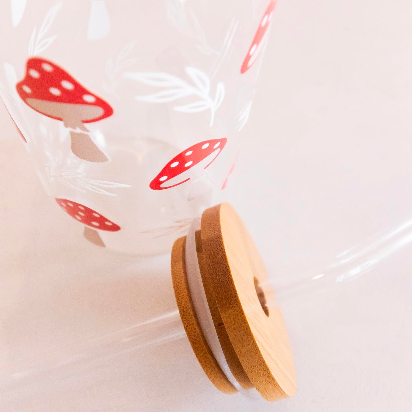 Eco-friendly glass tumbler featuring a whimsical mushroom design, complete with a bamboo lid and reusable glass straw, perfect for stylish and sustainable hydration.