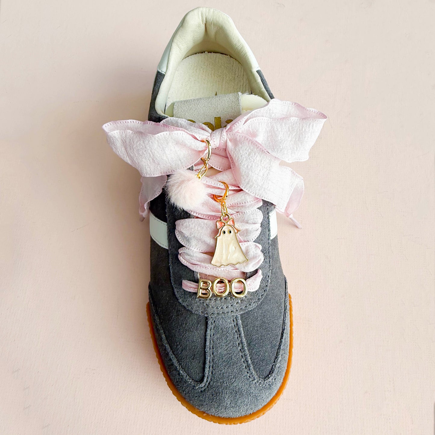 Close-up of ghost shoe charm and BOO letters on ribbon sneaker laces
