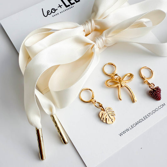 Ivory satin sneaker laces with gold aglets and three charms