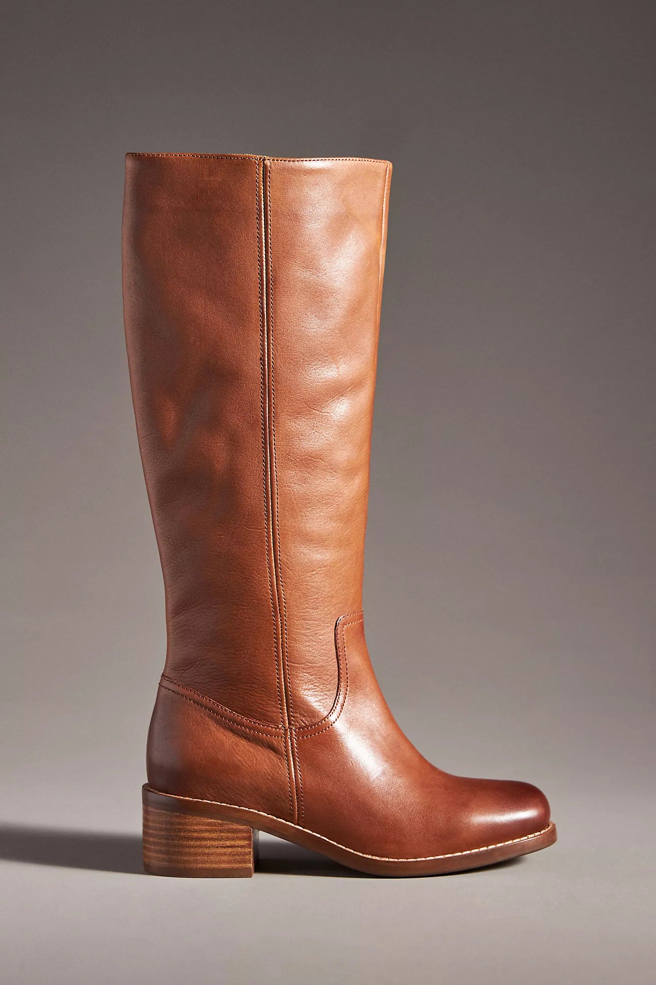 Brown knee-high boot on a gray background