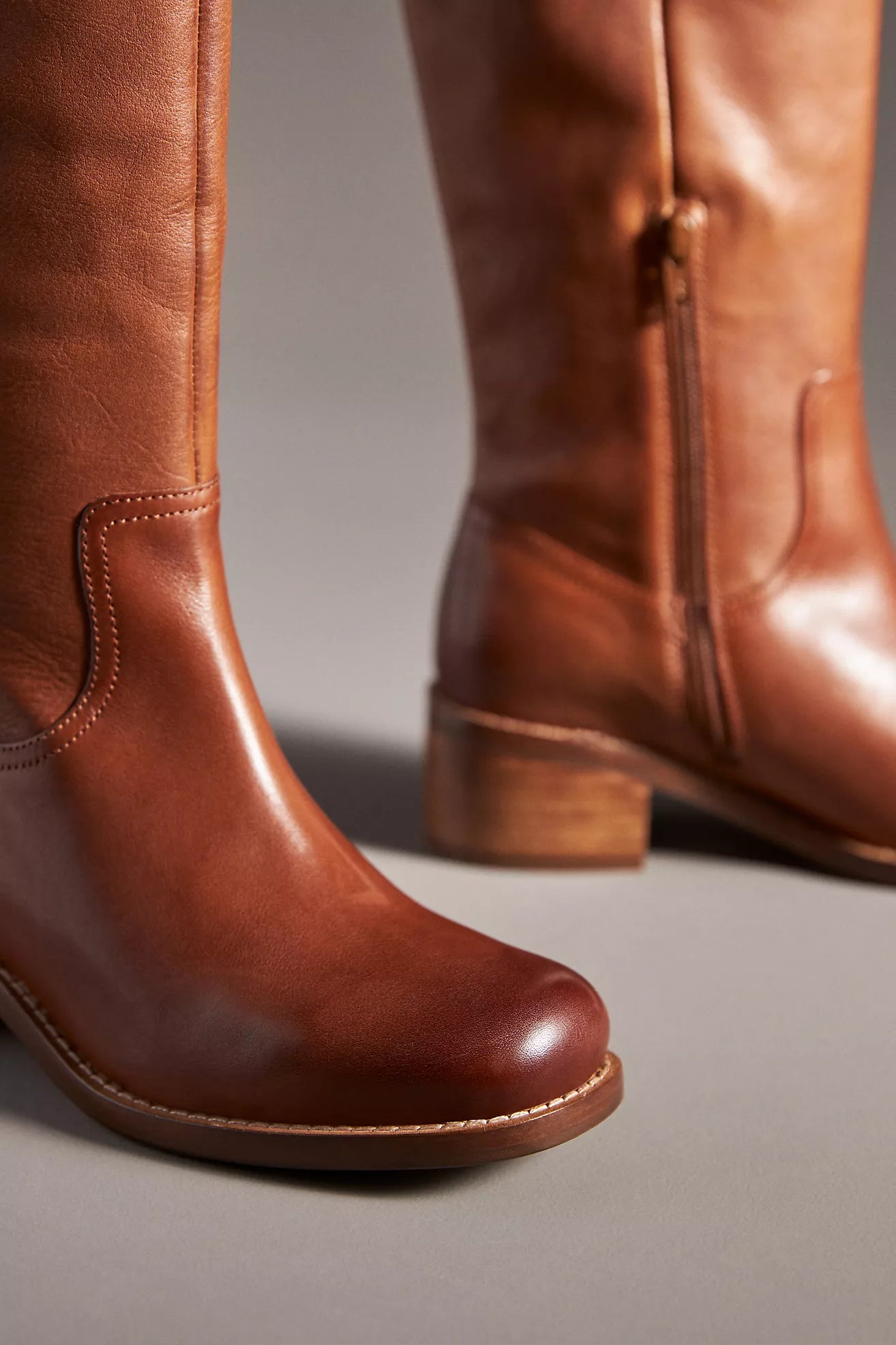 Pair of brown leather boots on a neutral background