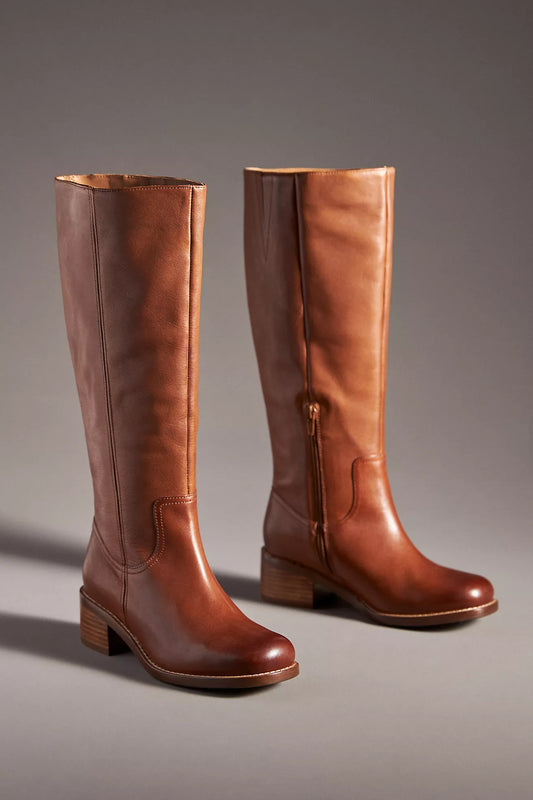 Pair of brown leather knee-high boots on a gray background