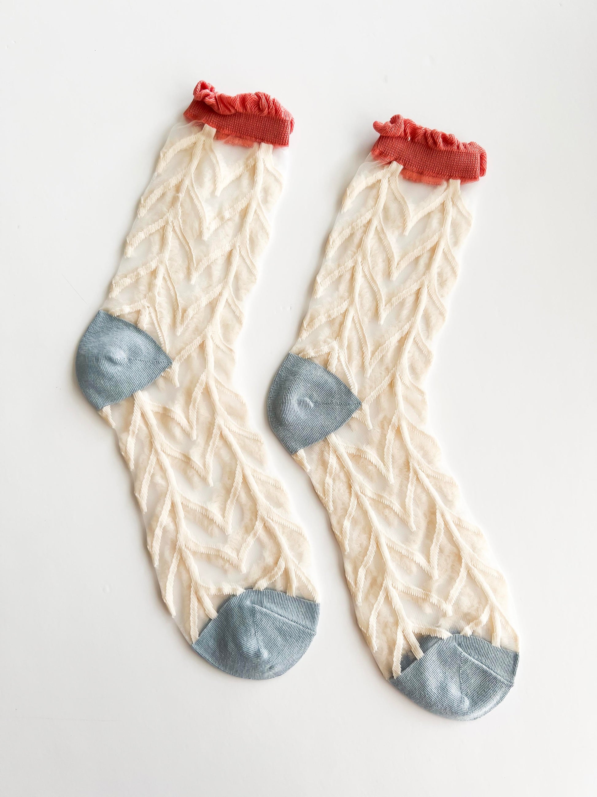 Transparent lace socks with a delicate blue bow and coral ruffled trim, stylish and breathable