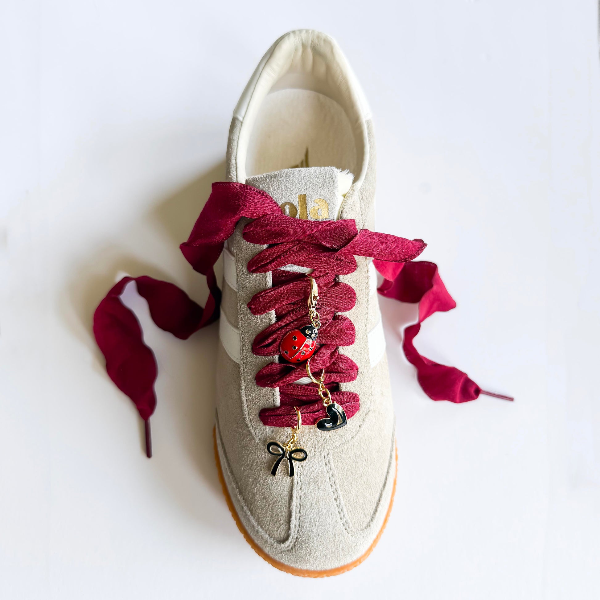 Close-up of Leo + Lee ladybug sneaker charm set on a gola sneaker