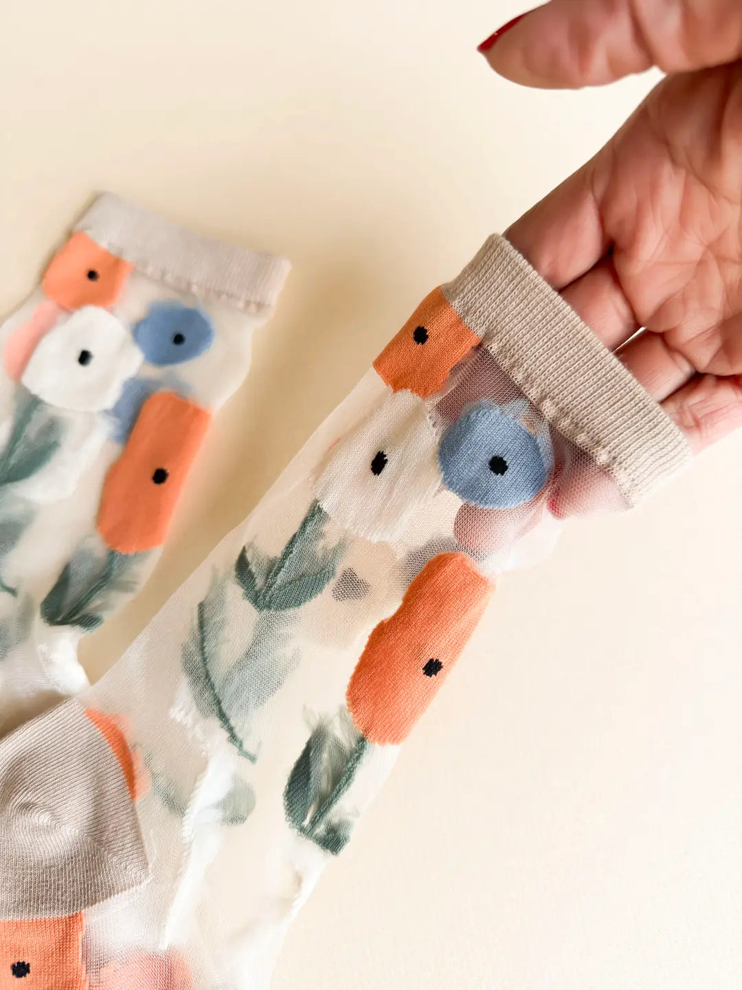 Close-up of a hand holding a piece of fabric with floral pattern