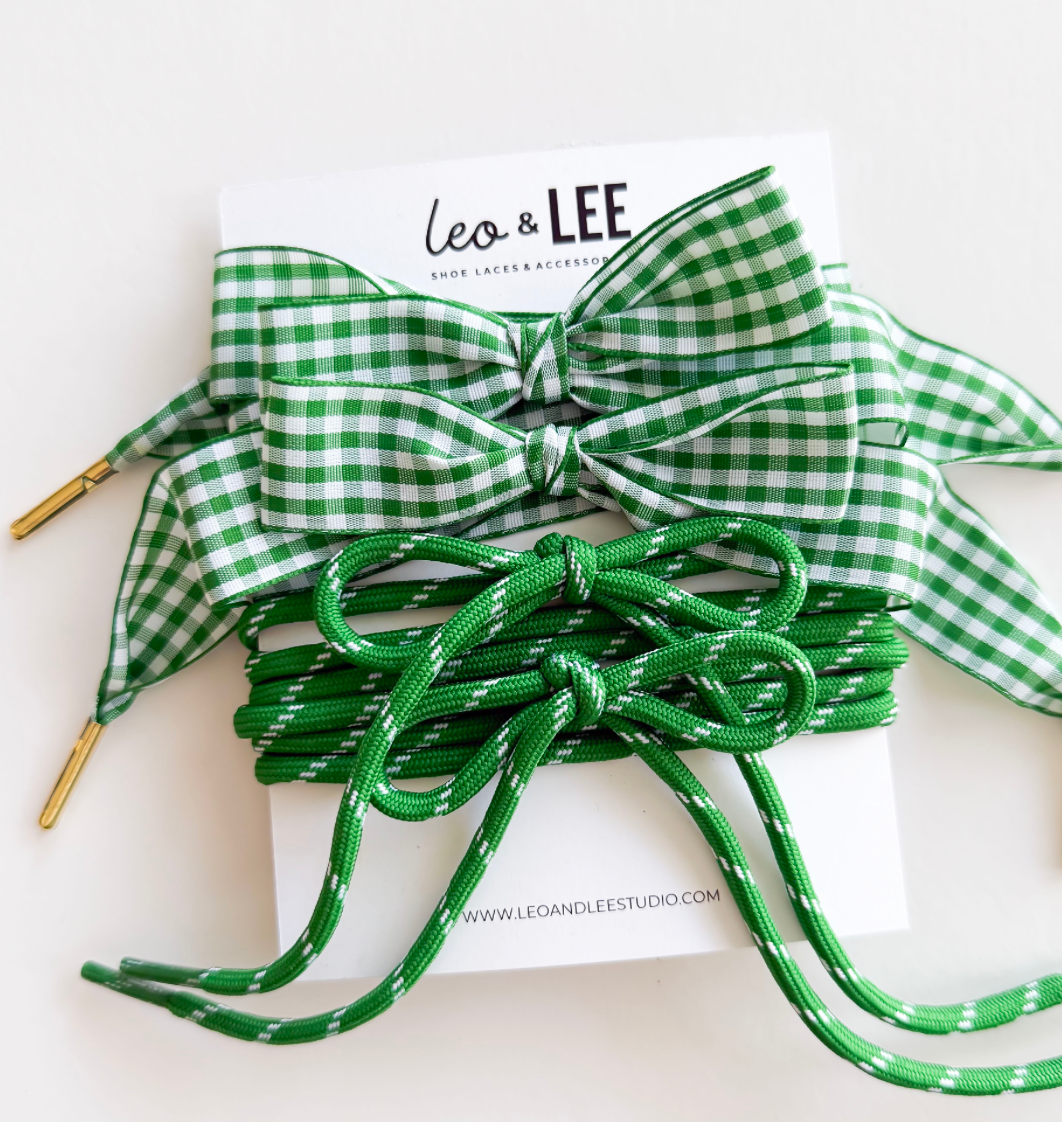 Green and white gingham ribbon bows and green braided shoelaces with gold-colored metal eyelets, displayed on a white backing card labeled 'Leo & LEE'.