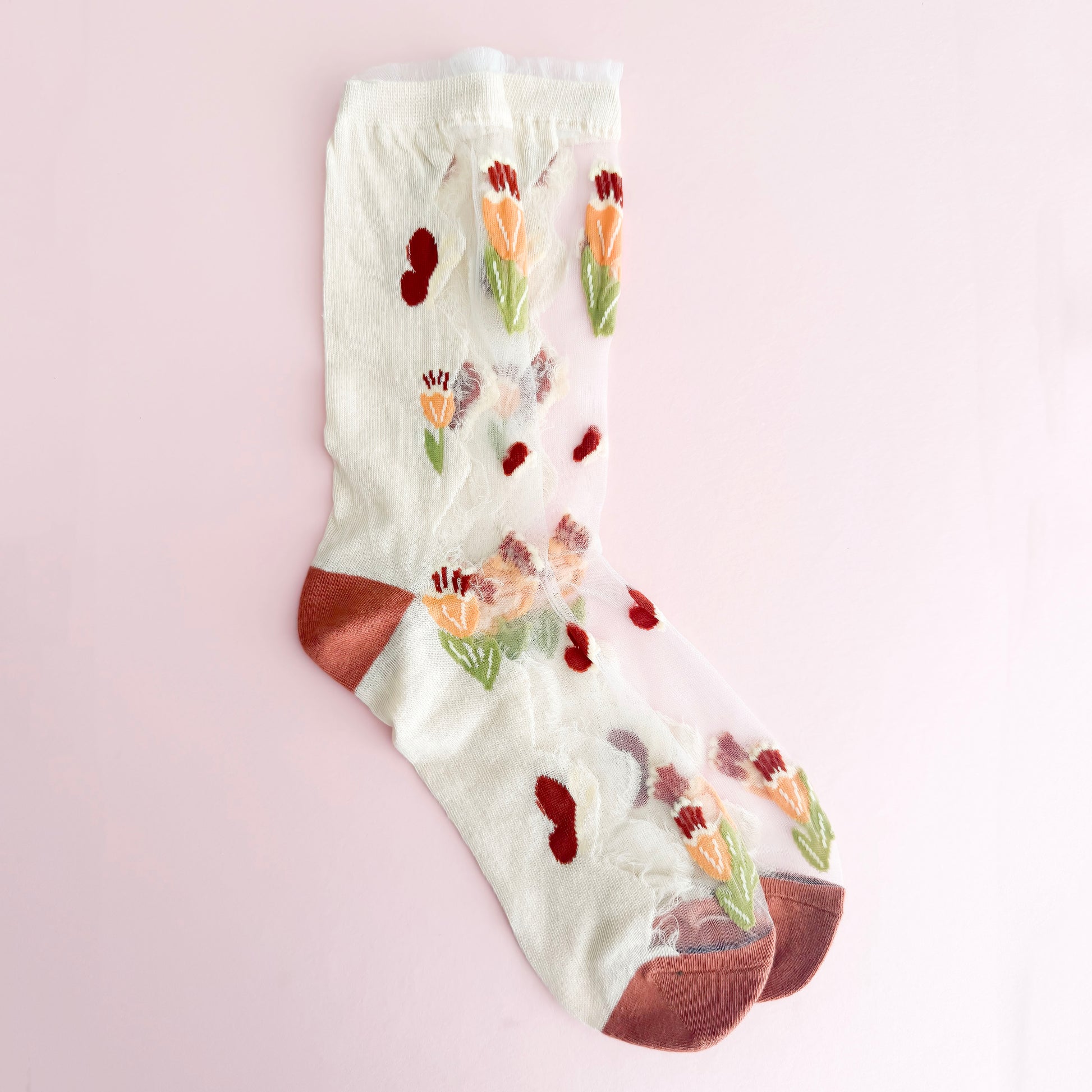 Floral-patterned sock on a light pink background
