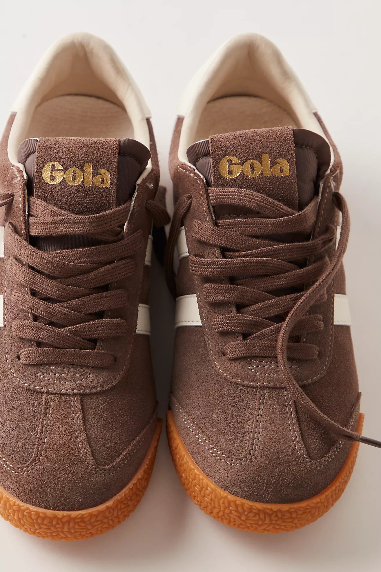 Pair of brown Gola sneakers on a light background