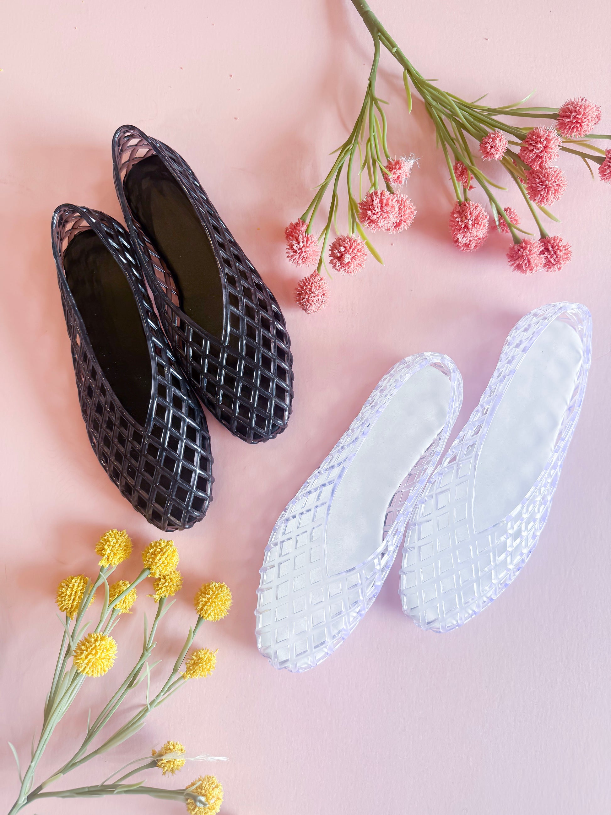 Black and white woven shoes on a pink background with flowers.