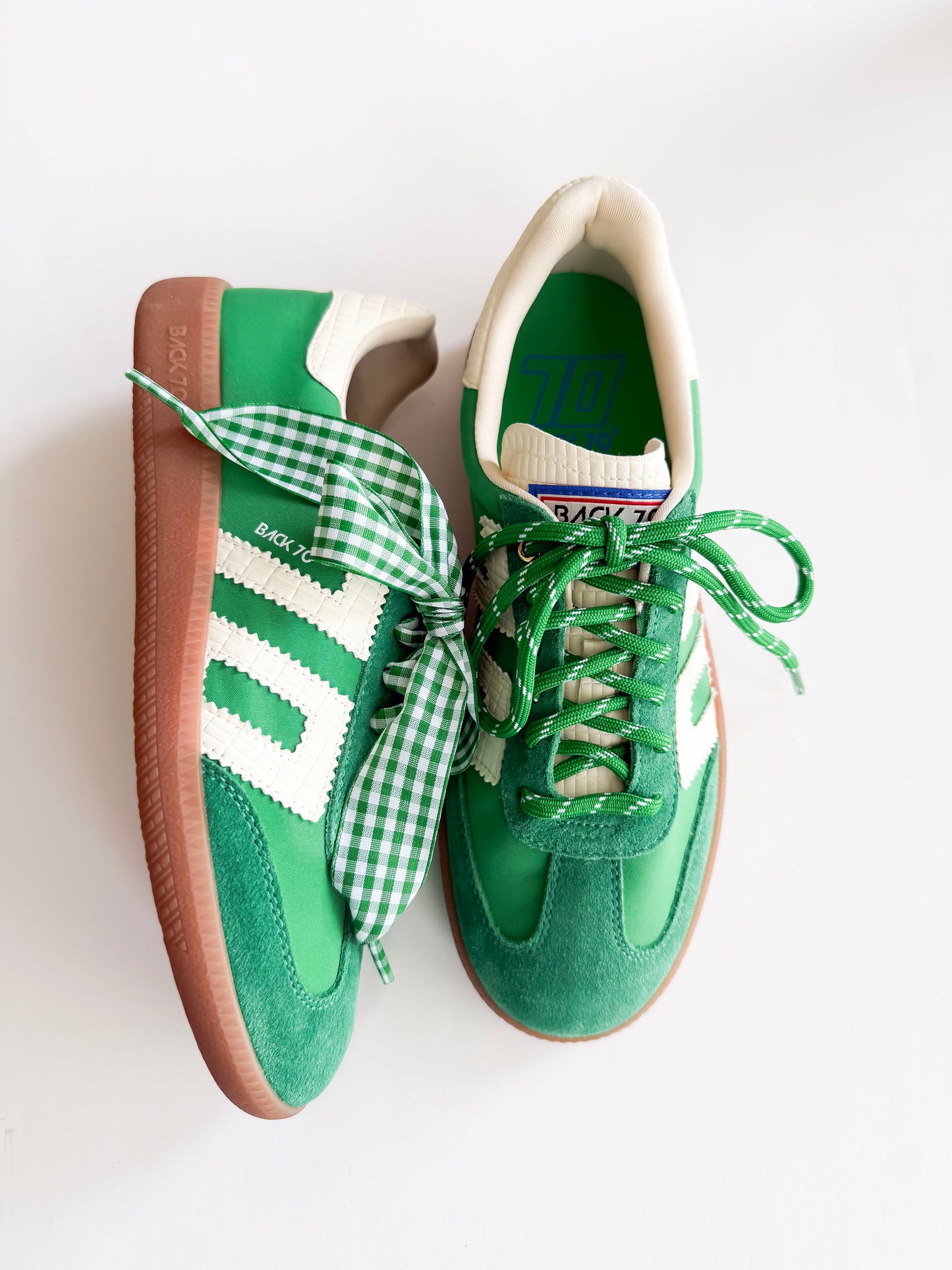 A pair of green and white Adidas Samba sneakers with green and white gingham checkered laces, displayed on a clean white background.