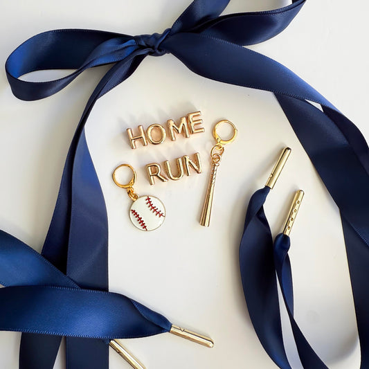 Navy satin sneaker laces with gold “HOME RUN” charms, baseball charm, and bat charm