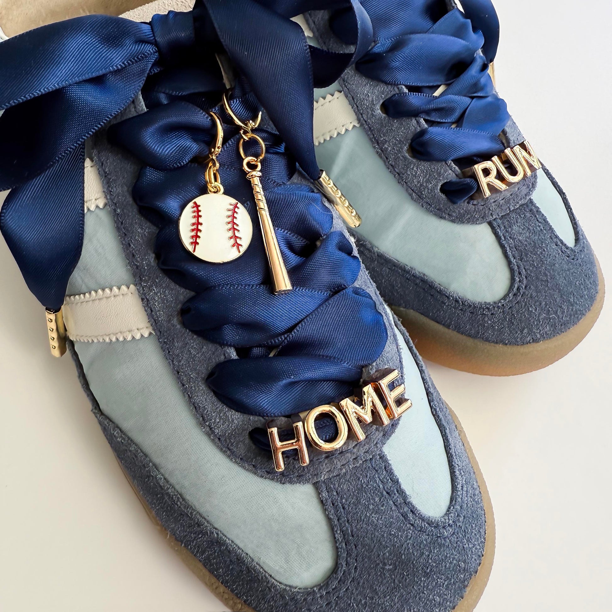 Blue sneakers with decorative laces and charms on a light background