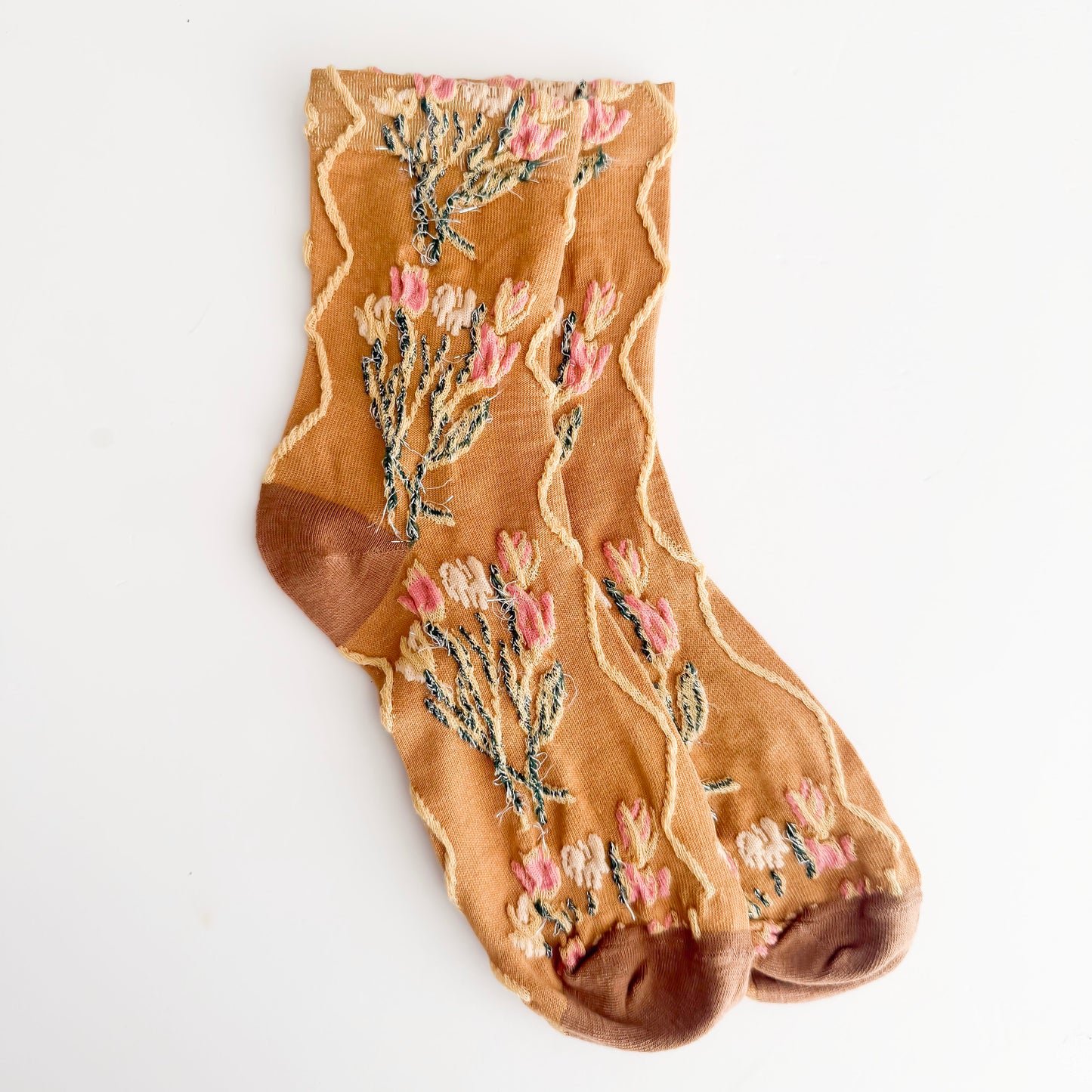 Tan sock with floral pattern on a white background