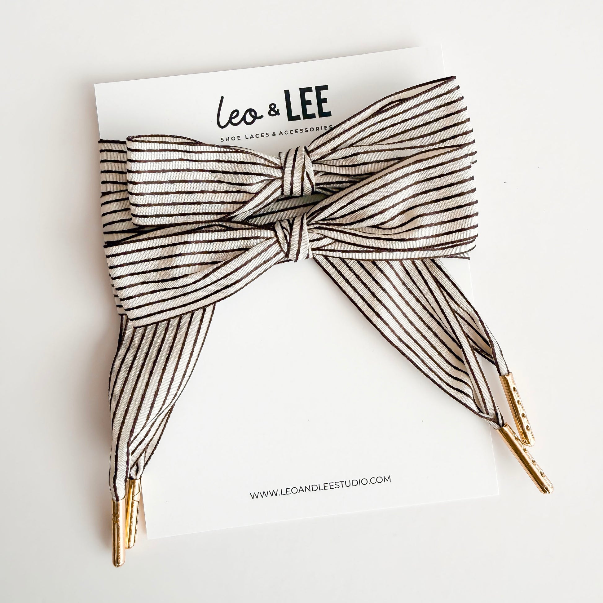 Striped shoelaces with gold tips on a white background with 'Leo & Lee' branding.