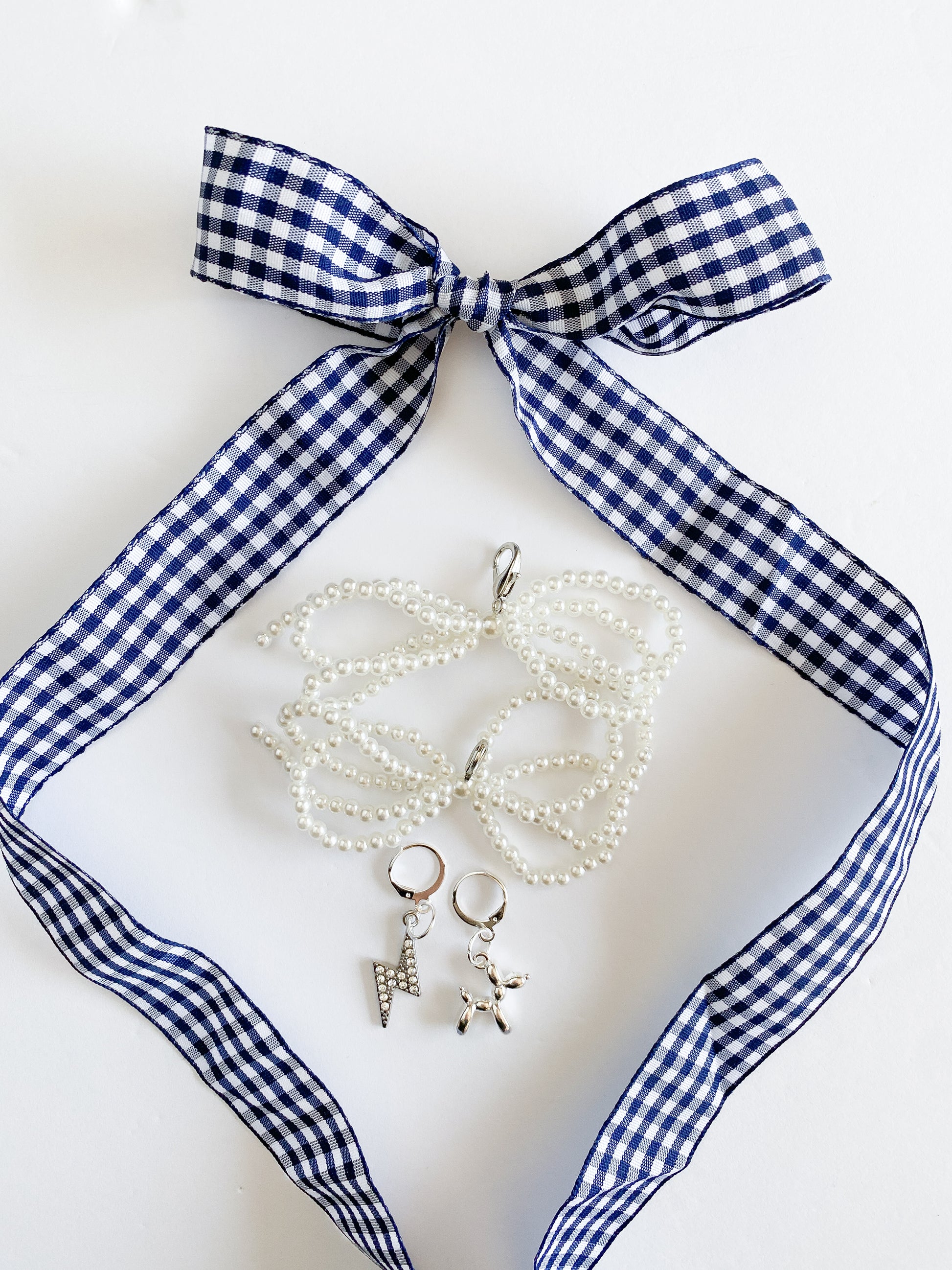 Necklace with charms on a blue and white checkered ribbon