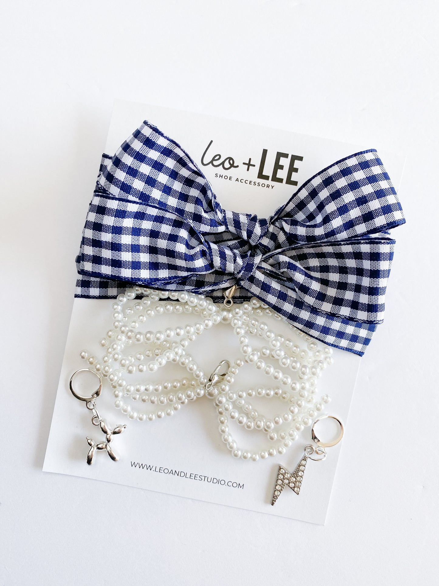 Blue and white checkered bow hair accessory with pearl keychain on a white background