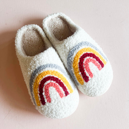 Pair of cozy slippers with a boho-colored rainbow design, featuring soft, warm material and a comfortable fit