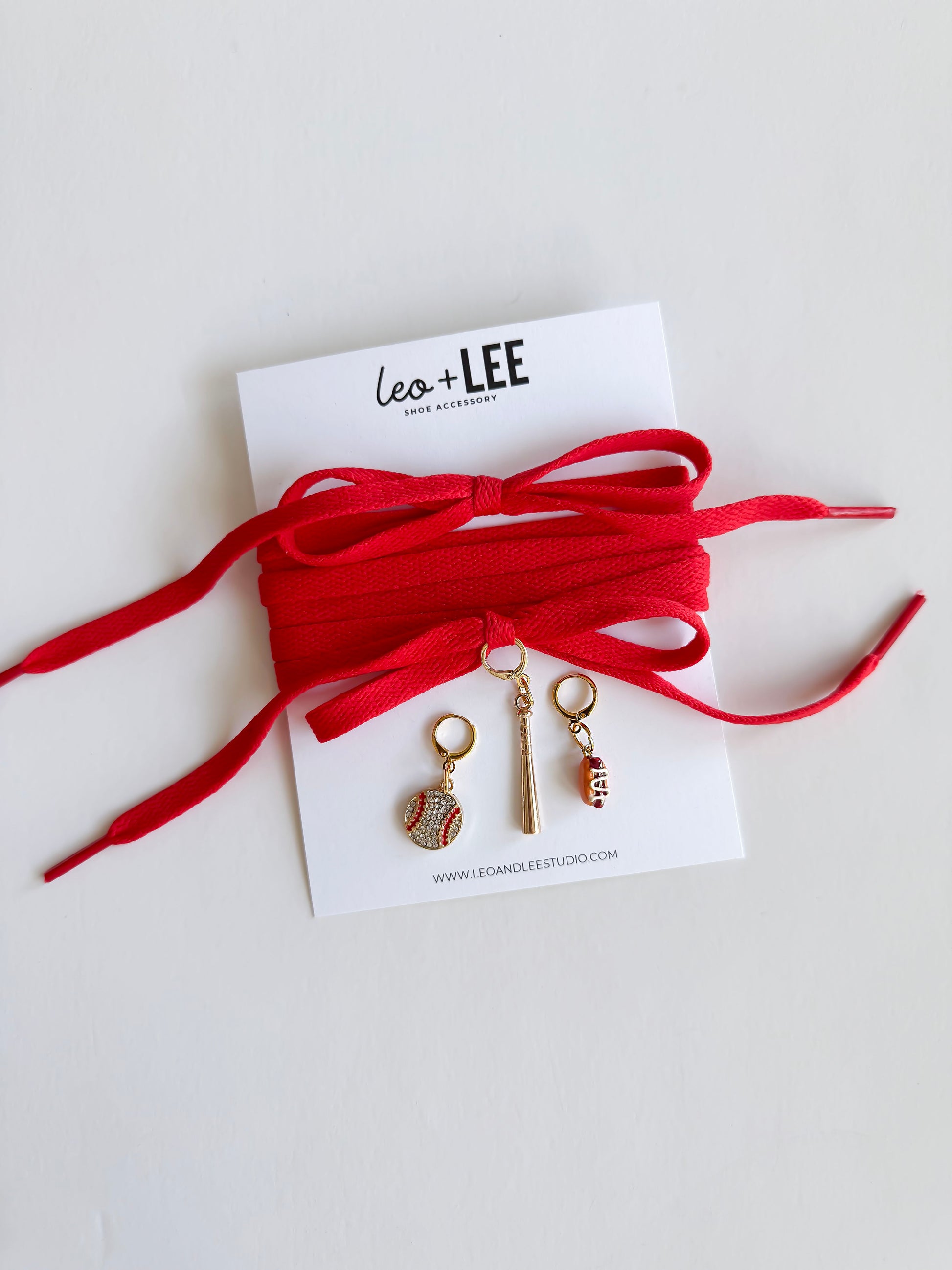 baseball-shaped charms on white cards with red, blue, and black ribbons.
